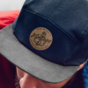 Black cap with brown faux leather patch logo